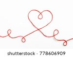 Red woolen thread in the shape of heart on white background. Valentine's Day