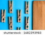 Wooden clothespins on a blue background with a Board for cutting products.Perfectionism.Symmetrically laid out items.Household.