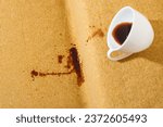 Small photo of Accidental coffee spill on the sofa, creating a brown stain that marred the upholstery, sofa or couch. Spoiled fabric-covered. Cleaning and stain removal concept. High quality photo