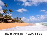 Beach in Hikkaduwa, Sri Lanka. Beautiful tropical beach with great waves for surfing. Beach bars and palm trees with coconuts on beach in Hikkaduwa, Sri Lanka.