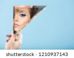 Small photo of Woman looking at her self reflected in a mirror, selfie, vanity, conceit, ego, digital narcissism concept minimal flat design. An illusion, beautiful girl with a mirror in her hands