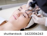 Small photo of Unidentified master in gloves and in robe measures the proportions of eyebrows with special instrument and holds pencil. Concept of microblading and beauty industry