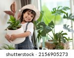 Potted plants at home held by a cute kid