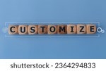 Small photo of Customize word and tools icons on wood block. customize word is made of wooden building blocks lying customize, business concept, on a blue background