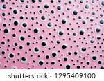 Many googly eyes organized over pink background