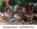 Small photo of excavator crusher machine breaks rocks to widen road