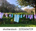Tie dye washing line no branding pink  blue t-shirts, socks and knickers drying on a washing line on sunny day kids craft project