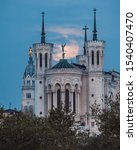 Small photo of Fourviere basilica at sunrise with the full moon setting behind the chucrch, creating a holy feeling, glorification of St. Michael and the statue of Virgin Mary. Peace, quietness, greatness, spiritual