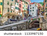 colorful houses overlooking rocks of the marina of Riomaggiore, sea village of Cinque Terre in Italy