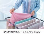 Housewife hangs wet laundry on the clothes dryer