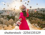 Girl traveler vacations beautiful destination in Goreme, Turkey. Follow me to fabulous Kapadokya with flying air balloons at sunrise, Anatolia