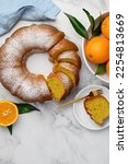 Small photo of Sliced orange bundt cake dusted with powdered sugar. Fruity citrus dessert. Copy space. Top view