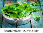 raw fresh organic spinach in a bowl on wooden rustic table