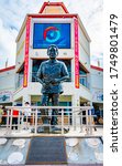Small photo of Philipsburg, Sint Maarten - November 16 2018: Life size statue/ sculpture of Dr. Albert Claudius Wathey, a powerful and historical political figure in the country. Duty Free shops and tourists behind.