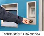 Small photo of A person using a credit card in a self service ticket machine to purchase a travel ticket