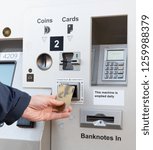 Small photo of A person uses a contactless payment card to complete a purchase at a self service ticket machine