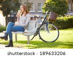Woman Relaxing On Park Bench...