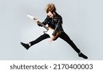 Small photo of Brutal bearded man jumping with electric guitar. Rock musician. Heavy metal player. Music star.