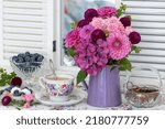Small photo of table decoration with bouquet od summer flowers, cup of coffee and blueberries