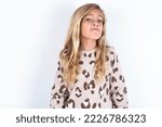 Small photo of caucasian teen girl wearing animal print sweater over white background with snobbish expression curving lips and raising eyebrows, looking with doubtful and skeptical expression, suspect and doubt.