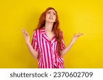 Young red haired woman wearing pink pyjama over yellow studio background crazy and mad shouting and yelling with aggressive expression and arms raised. Frustration concept.
