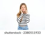 caucasian kid girl wearing striped T-shirt covering ears with fingers with annoyed expression for the noise of loud music. Deaf concept.