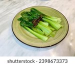 Small photo of Blanch vegetable (Bok Choy) garnished with fried onion on a plate.