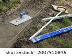old metal and wooden tools for construction or renovation. laying cement or concrete foundation for the garden fence. do it yourself 