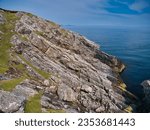 Small photo of Inclined rock strata near the Eilean Glas Lighthouse on Scalpay - Outer Hebrides Thrust Zone Mylonites Complex - Mylonite. Metamorphic bedrock formed between the Archean Eon and Ediacaran periods.