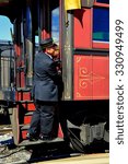 Small photo of Strasburg, Pennsylvania - October 16, 2015: Conductor on the parlor car stairway as a vintage passenger train departs the Strasburg Railroad station