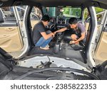 Small photo of in Quang Binh province, Vietnam - November 6, 2023: image of a repairman removing all the seats inside a car to clean the interior and redo the interior