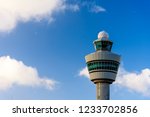 The tower in airport in Amsterdam. The tower against blue cloudy sky. Control tower in airport. Aviation observation post in airport in Netherlands.