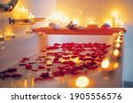 Small photo of Spiritual aura cleansing flower bath for full moon ritual with candles, aroma salt, lavender and rose petals. Body care and mental health routine.