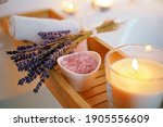 Small photo of Spiritual aura cleansing ritual bath for full moon ritual. Candles, aroma salt and lavender on tub table, close up