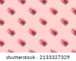Seamless pattern of pink macaron pastry french cookies on background with hard light shadow.