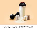 Small photo of whey or casein shake, whey smoothie with protein chocolate bar, weight training dumbbell on the side, creatine blend for muscle mass gain, copyspace