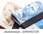 Small photo of wad of money from brazil, thousand reais in wad of money, 100 reais banknote, grand prize, copyspace, white background