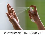 Caucasian woman wipes her hands with an alcohol-based hand-washing spray as a preventive hygiene measure against coronavirus ( Sars-CoV-2, Covid-19) infection. Antibacterial hand sanitizer gel.