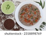 Small photo of Finger millet or Ragi uthappam. Healthy pan cake made of fermented batter of finger millet and lentils. Topped with onions, carrots, coriander and green chilies. Served with coriander chutney.