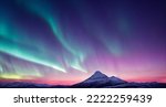 Small photo of Northern Lights over snowy mountains. Aurora borealis with starry in the night sky. Fantastic Winter Epic Magical Landscape of snowy Mountains.