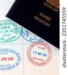 Small photo of Dubai, United Arab Emirates - August 2, 2023 UAE visa stamping, united arab emirates and indian official stamps on a passport page, letters mentioned in arabic and hindi language also