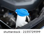 A blue plastic bottle cap of car windshield washer water storage tank. Vehicle equipment and object part photo. Selective focus.