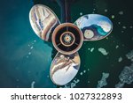 Close up image of  Three bladed stainless steel Boat Engine propeller in the water background.
