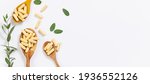 Small photo of Wooden spoons with vegan vitamin capsules for immunity support and healthy lifestyle on white background with fresh green eucalyptus twig. Long banner format.