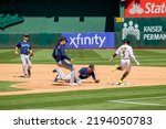 Small photo of Oakland, California - August 21, 2022: Oakland Athletics outfielder Tony Kemp beats out an infield single against the Seattle Mariners at the Oakland Coliseum.