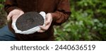 Small photo of Man holding round disk of traditional Chinese shu puer ttea outdoors, banner shot