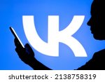 Small photo of March 25, 2022, Brazil. In this photo illustration, a woman's silhouette holds a smartphone with a VKontakte (VK) logo in the background. It is a social network based in Saint Petersburg, Russia