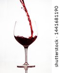 Small photo of Filling the glass with wine. When pouring a red wine, fill up the glass a third of the way to allow for aeration. Enjoying wine without pretense. pouring wine art.