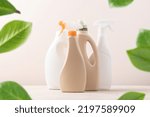 Bottles with cleaning agent on beige background in frame of green leaves. Creative eco cleaning concept. Environmentally friendly home and office cleaning