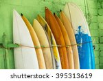 Small photo of Set of different color surf boards in a stack by ocean.Bali,Indonesia. Surf boards on sandy Weligama beach. On Weligama beach surf is available all year around for beginner and advanced.